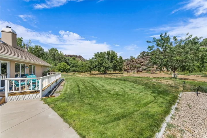 Expansive lawn with natural rock formations and mature trees