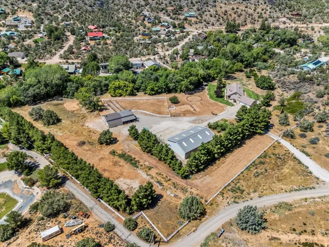 Expansive property featuring multiple structures, including a primary residence, a large metal-roofed outbuilding, and a secondary barn-style structure