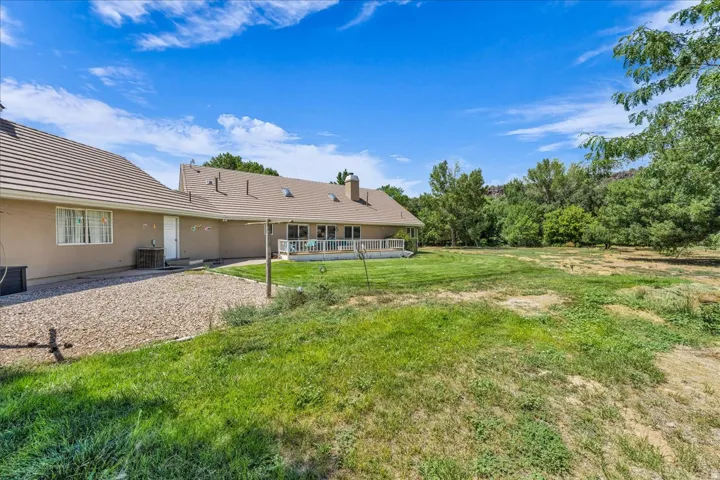 Expansive exterior with a covered patio, multiple skylights, and a gravel hardscape area