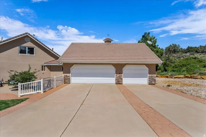 Two-car garage with tile roof and decorative stone accents