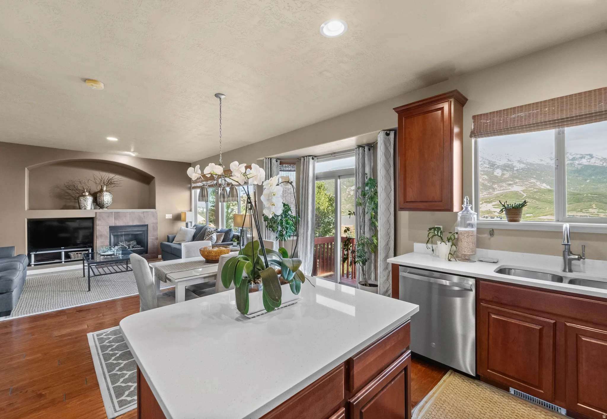 Wood-finish flooring throughout, kitchen with stone countertops, stainless steel appliances, and wood cabinetry