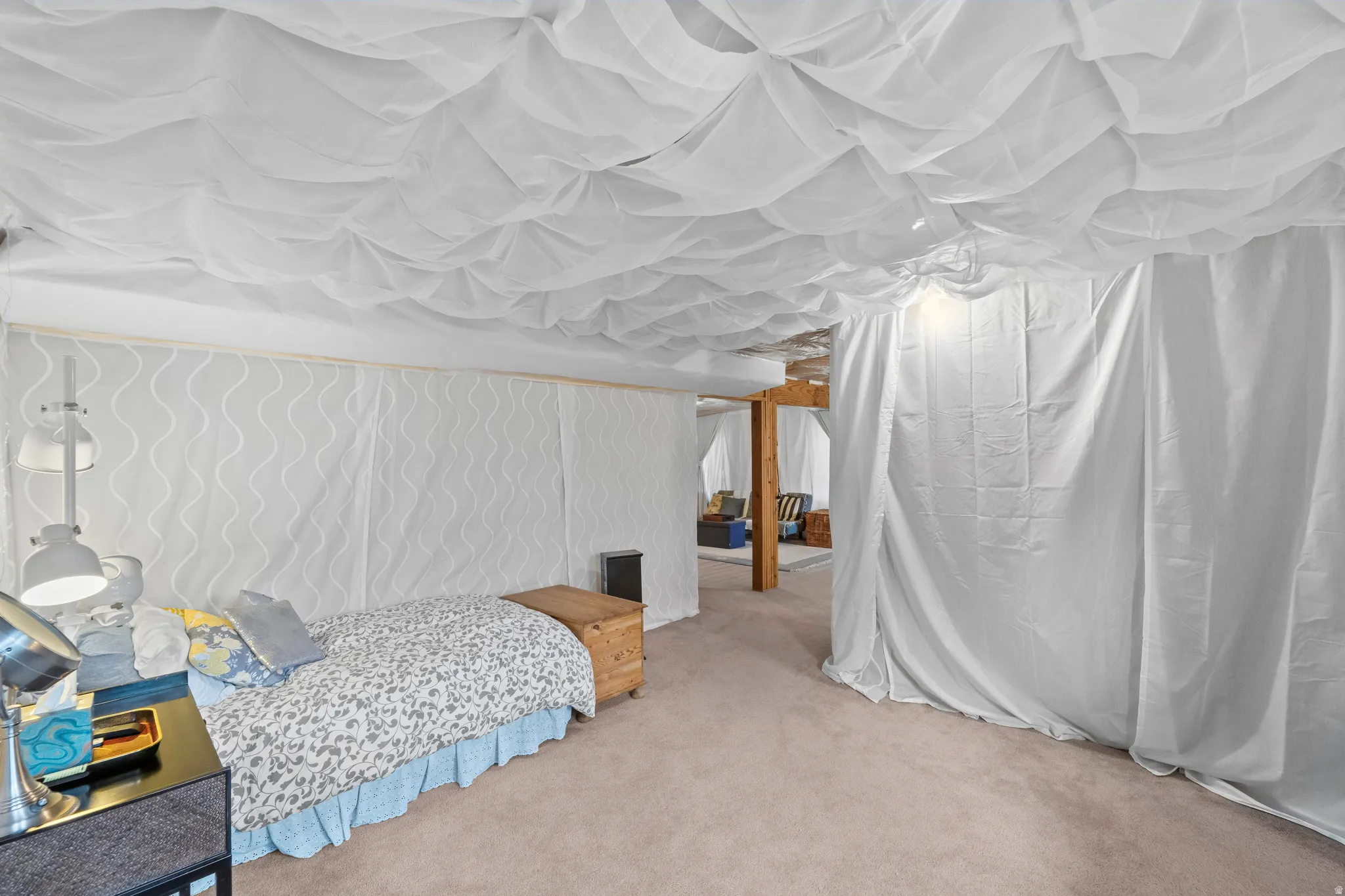 Carpeted room featuring draped fabric ceiling and wall coverings