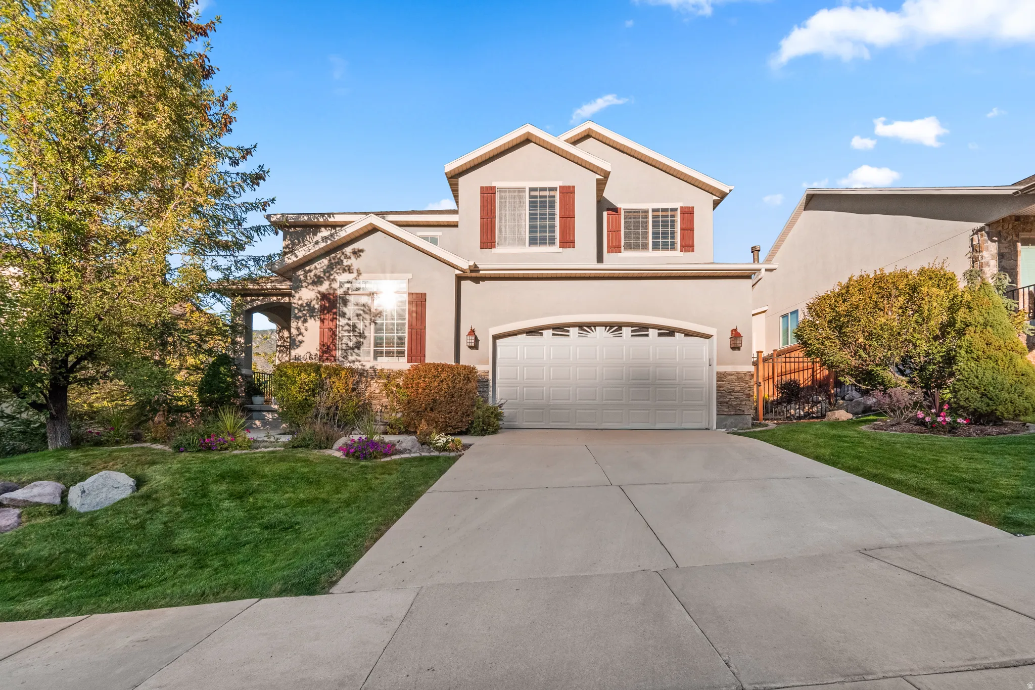 Beautiful Two-story stucco exterior with stone accents, a two-car garage, and a concrete driveway