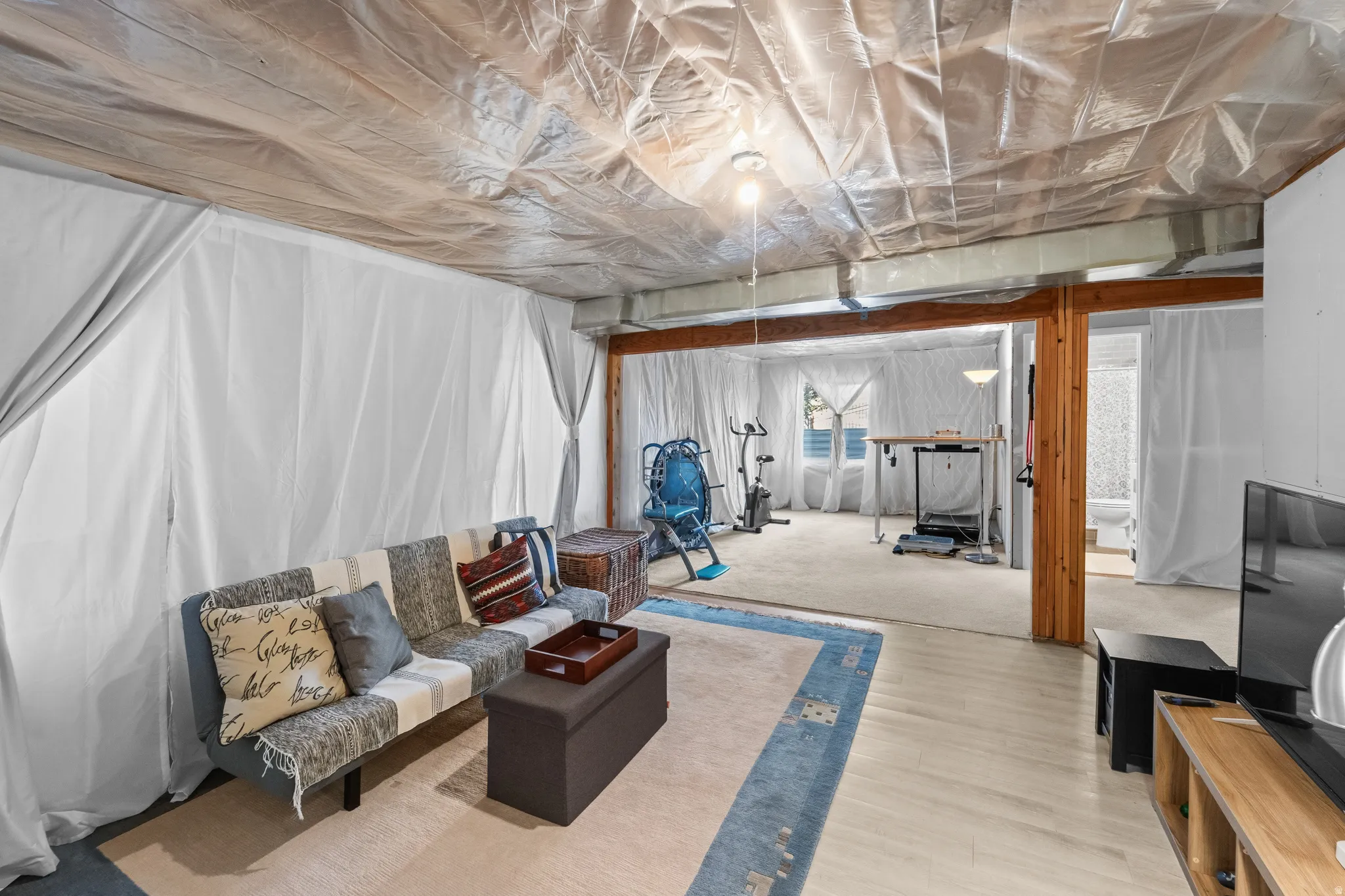 Basement almost finished Open lower-level space with wood-finish flooring, exposed wooden beams, and recessed lighting