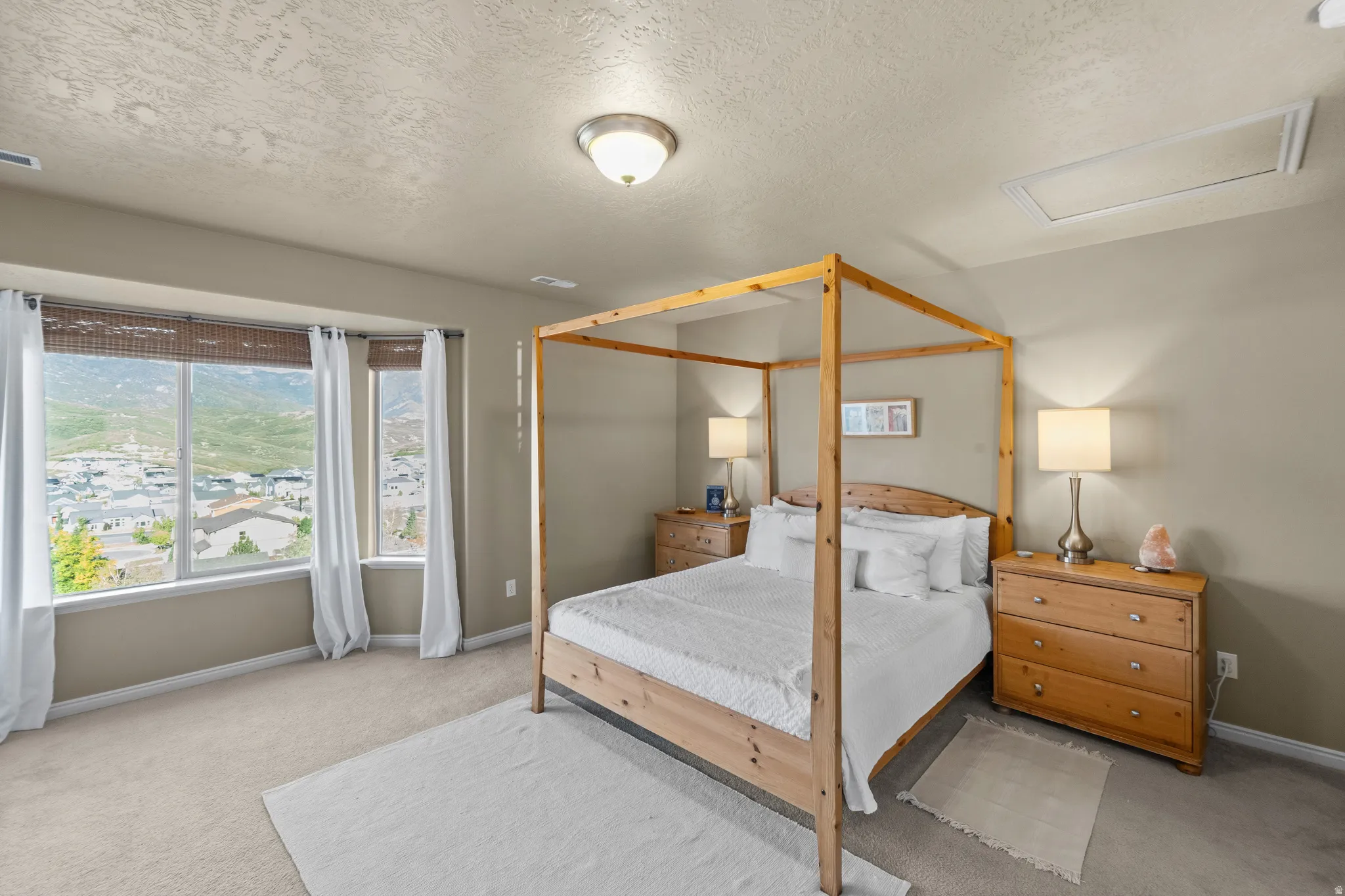 Master Suite Bay window with integrated window treatments, wall-to-wall carpeting, and a flush-mount ceiling light