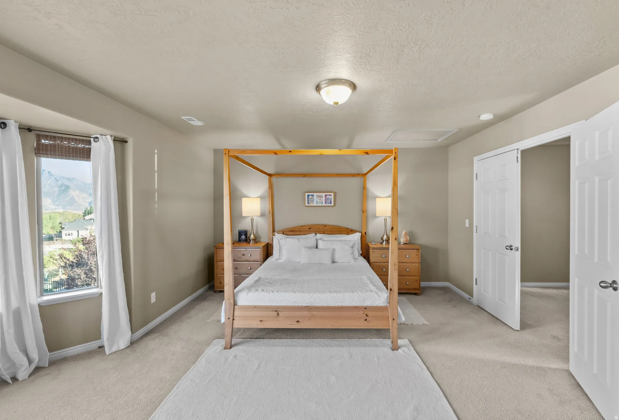Master Suite - Carpeted flooring, neutral wall tones, window with mountain backdrop, and white paneled doors