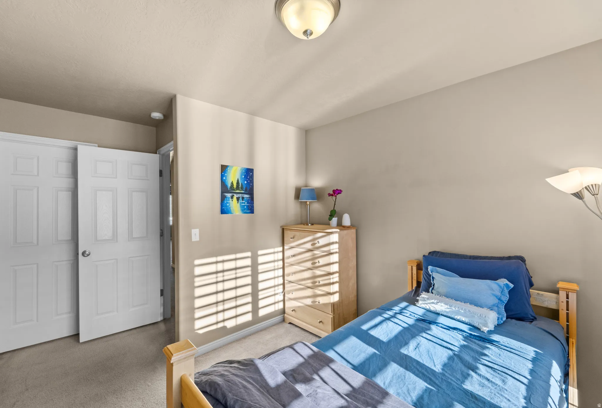 Bedroom 2 - Recessed lighting, wood-finish dresser, neutral wall color, carpet flooring, and a six-panel bi-fold closet door
