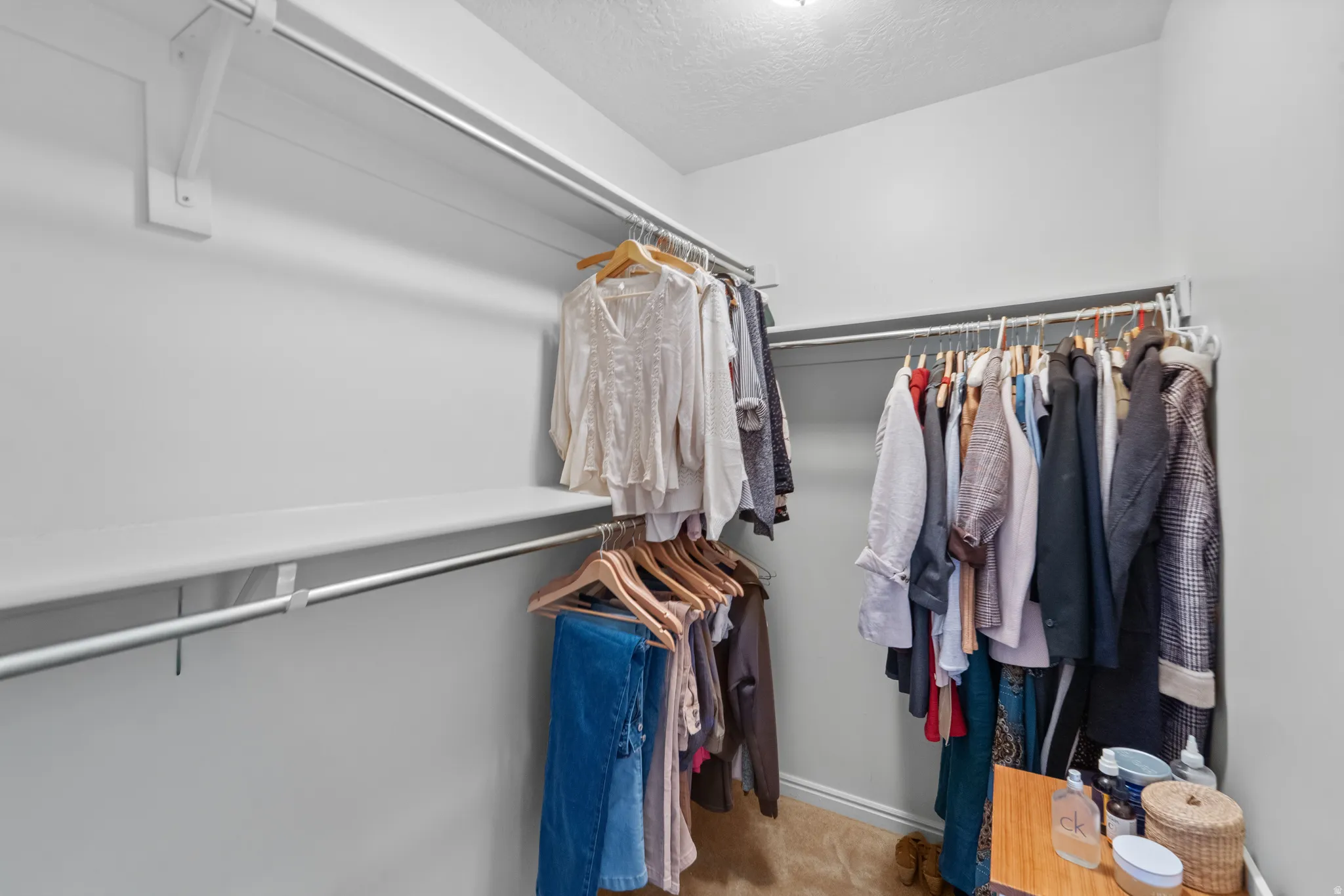 Master Suite Walk in Closet . Right half of the walk in closet in Master Suite. Walk-in closet with carpet flooring, white walls, and built-in shelving