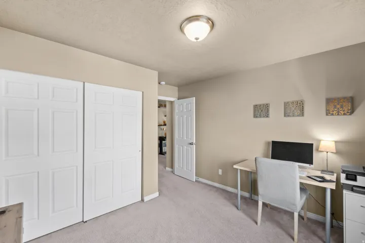 Bedroom 4 Neutral-toned walls, light carpeted flooring, white bi-fold closet doors, and an overhead flush-mount light fixture