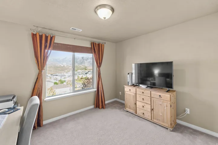 Bedroom 4 Neutral tone wall paint, flush mount ceiling light, carpeted flooring, and a large window with mountain scenery