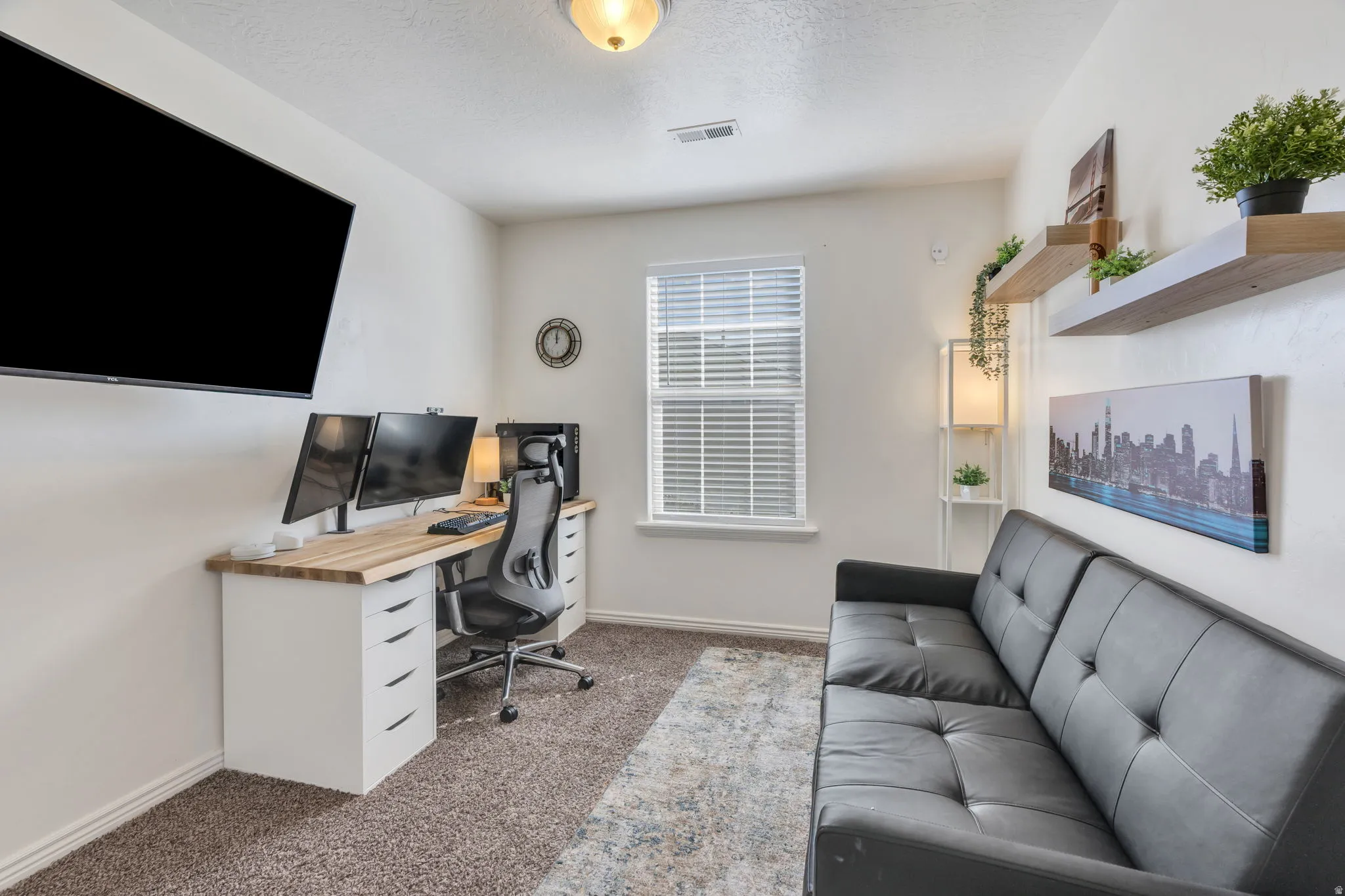 Recessed lighting, window with blinds, wall-mounted display, built-in shelving, and carpeted flooring
