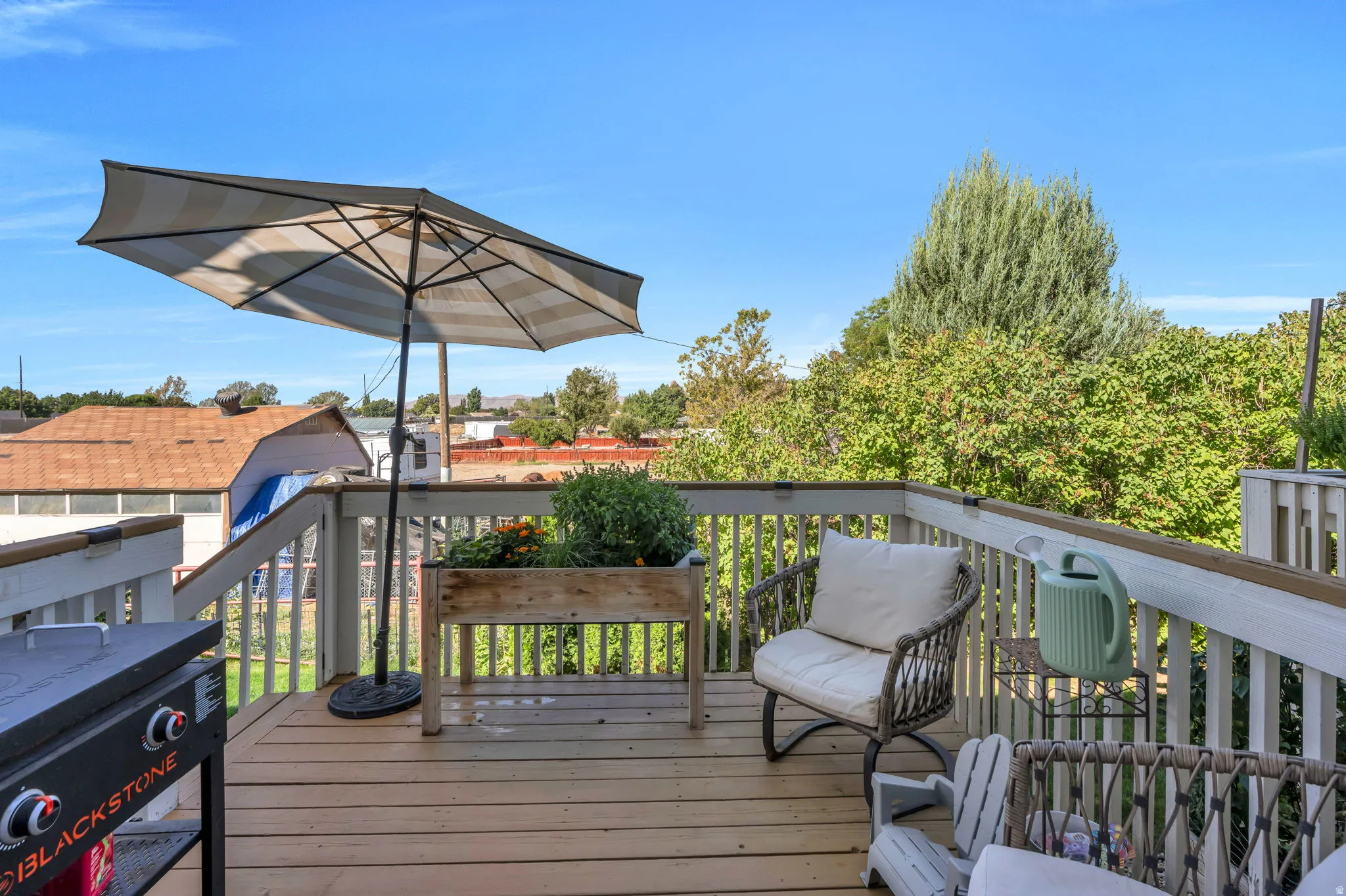 Expansive outdoor deck featuring wood-finish flooring and white railings