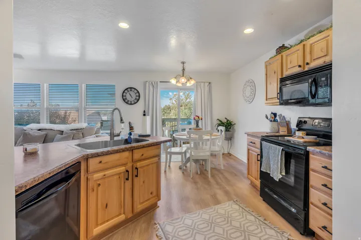 Kitchen featuring wood-finish cabinetry, black appliances, and laminate countertops
