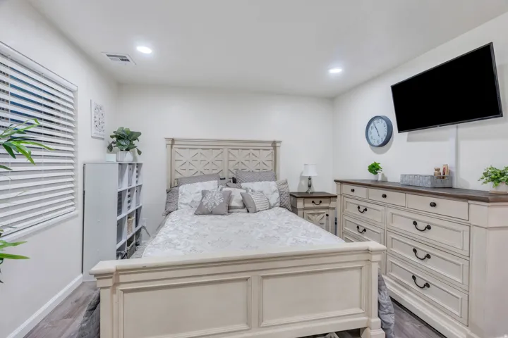 Recessed ceiling lighting illuminates the room with wood-finish flooring