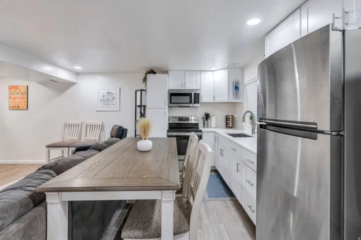 Kitchen featuring stainless steel appliances, white cabinetry, undermount sink, and light-toned countertops