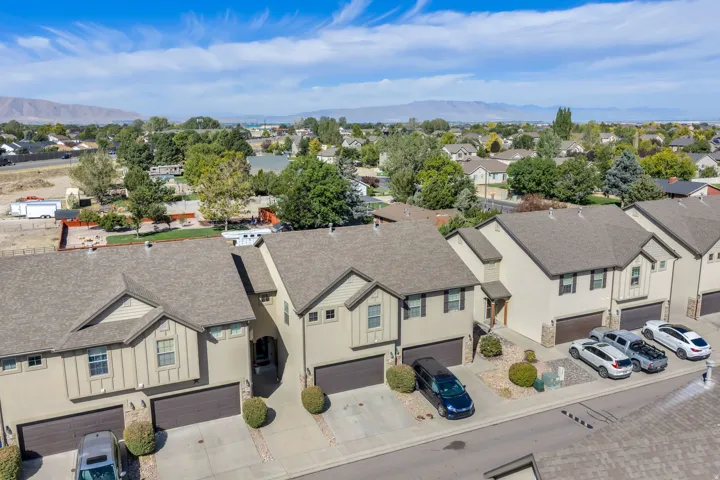 Stucco exterior with stone accents, attached garages, and individual driveways