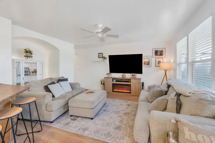 Spacious living area featuring wood-finish flooring, an arched doorway, and built-in shelving