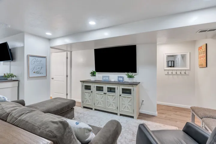 Recessed lighting illuminates the space, featuring white walls and a light wood-finish flooring