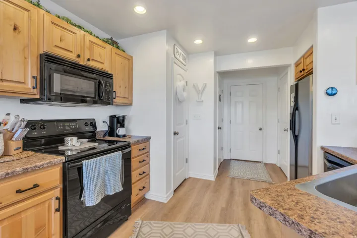 Wood-finish cabinetry paired with black appliances