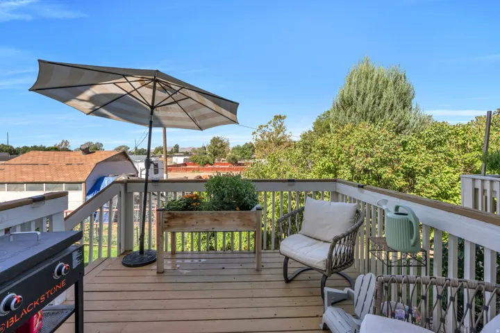 Expansive outdoor deck featuring wood-finish flooring and white railings