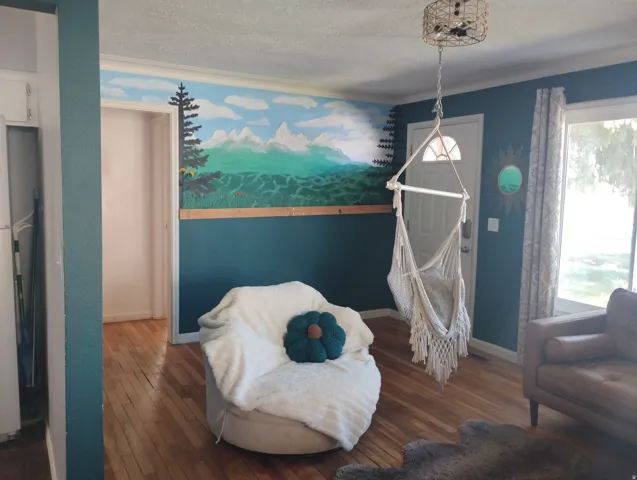 Hardwood flooring, painted accent wall, white trim, recessed doorway, pendant light fixture