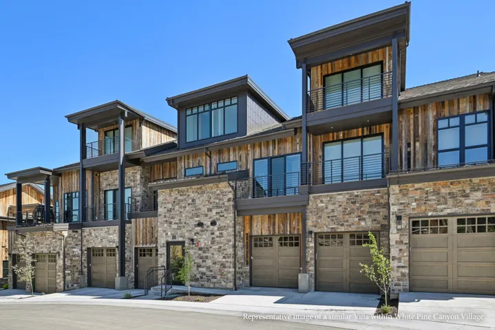 Stone and wood-clad exterior with multiple balconies, large windows, and integrated garage doors
