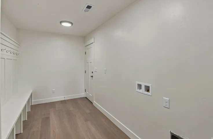 Wood-finish flooring, built-in storage bench, and wall-mounted coat hooks
