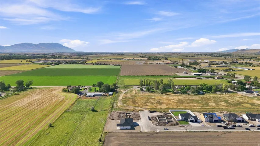 Expansive surrounding agricultural fields, distant mountains, and developed residential areas