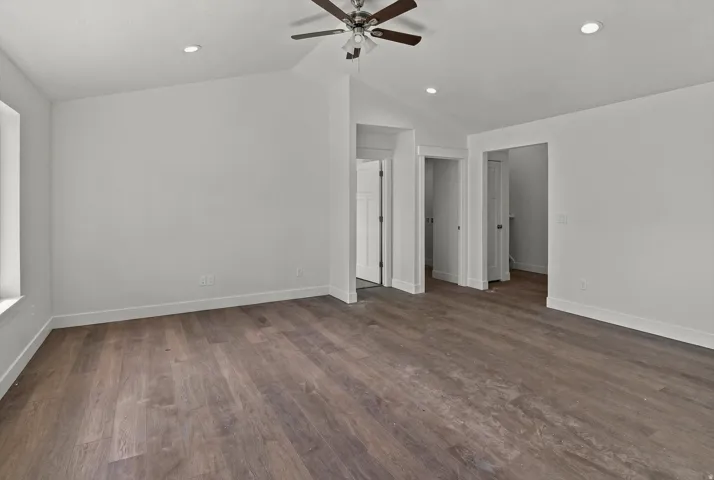 Spacious room featuring wood-finish flooring, recessed lighting, and a ceiling fan