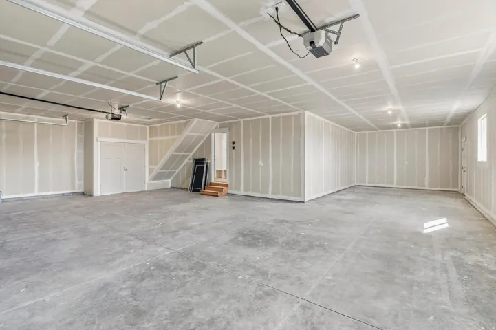 Expansive garage space with concrete flooring, recessed lighting, and a window for natural illumination