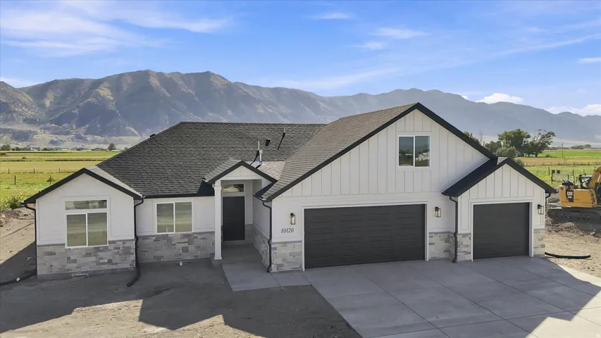 Contemporary exterior with gray stone veneer and white siding, featuring a dark asphalt shingle roof and a two-car garage