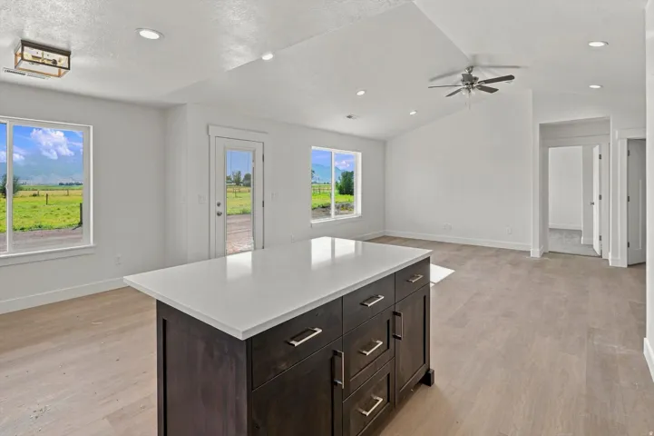 Kitchen island with white countertop and dark wood-finish cabinetry