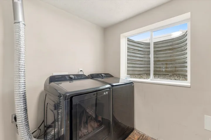 Dedicated laundry area with a window providing natural light, durable flooring, and light-toned walls