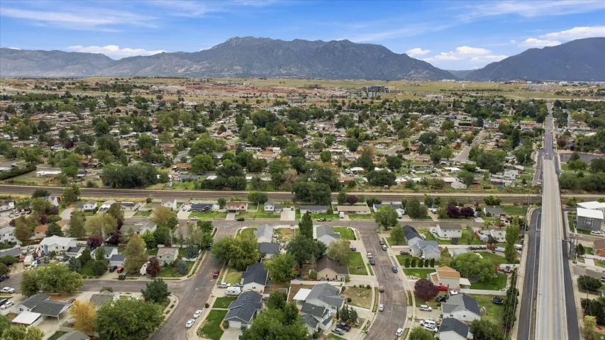 Expansive residential area with mature trees, mountain backdrop, and multiple streets