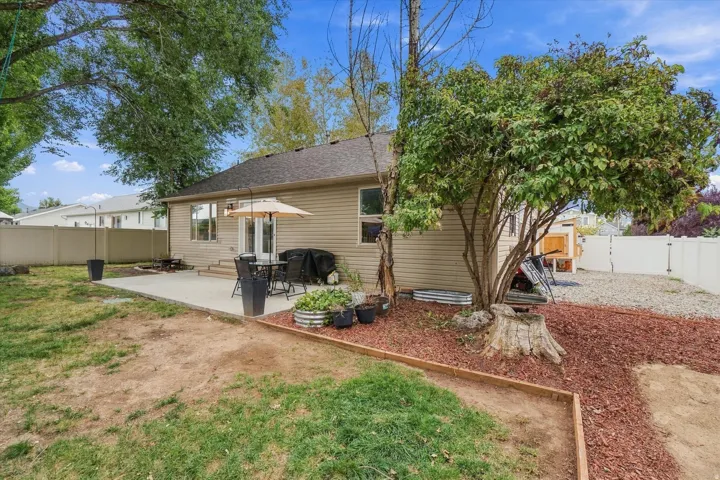 Rear exterior featuring siding, dual-pane windows, and a paved patio
