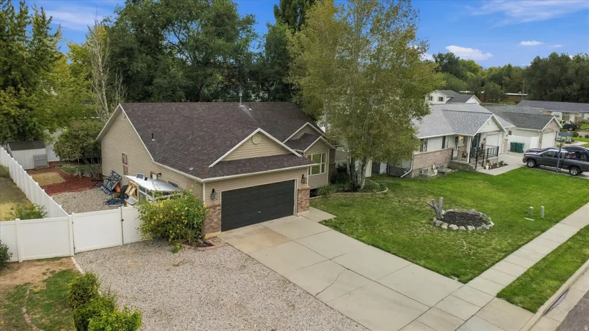 Property featuring a gravel driveway, an attached garage, a covered front porch, and a fenced side yard with a storage shed