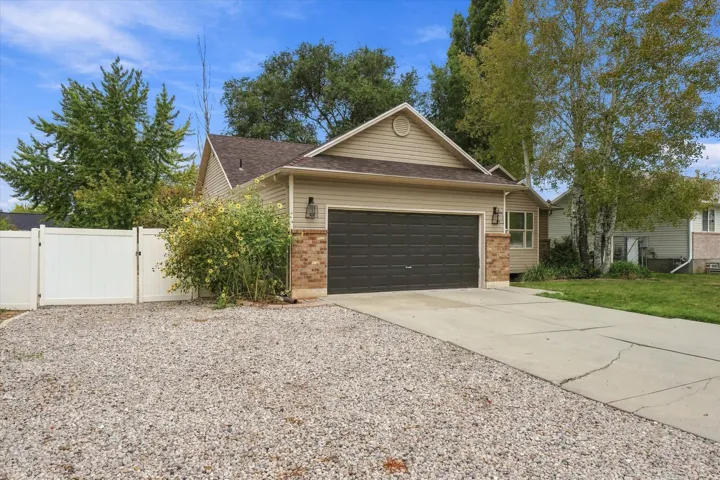 Two-car garage with paneled door, stone facade accents, and concrete driveway