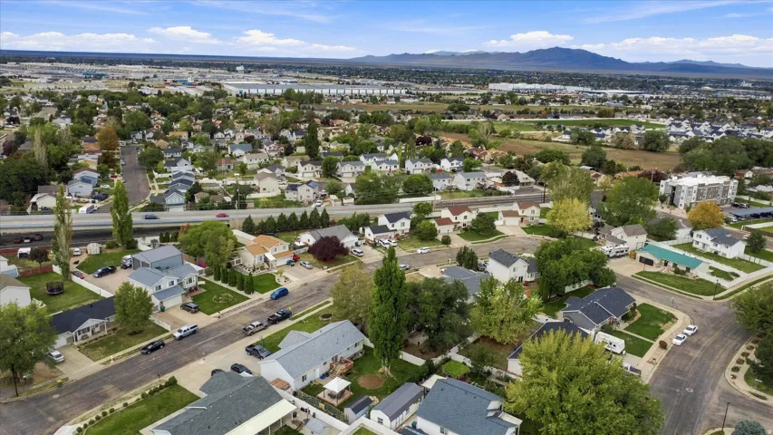 Residential neighborhood with varied architectural styles, mature trees, and mountainous backdrop