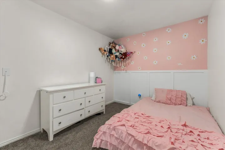 Carpeted flooring, white wainscoting, and a decorative wall treatment