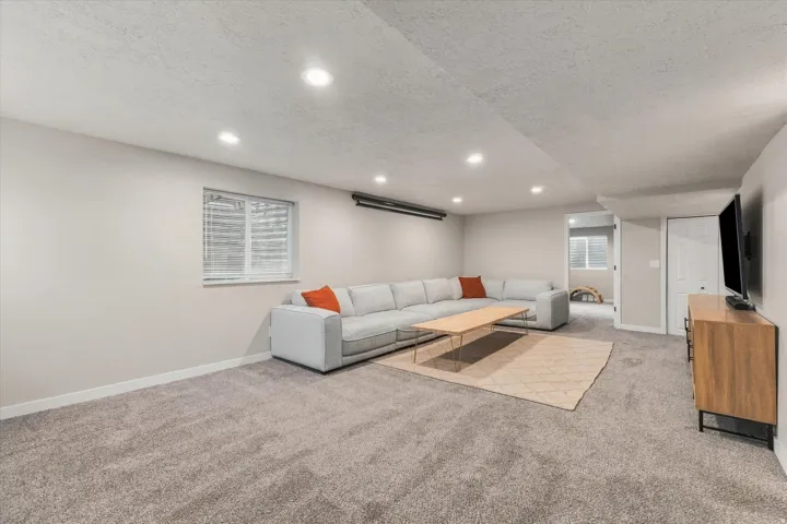 Recessed lighting illuminates the carpeted floor and painted walls