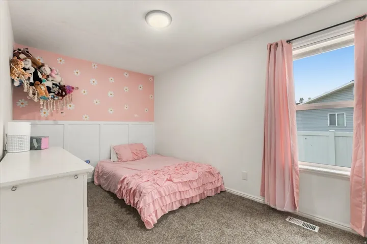 Wall-to-wall carpeting and a single window with a privacy fence visible beyond