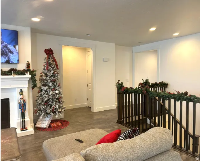Christmas time. Recessed lighting, wood-finish flooring, white trim, and a dark wood staircase with spindle railing