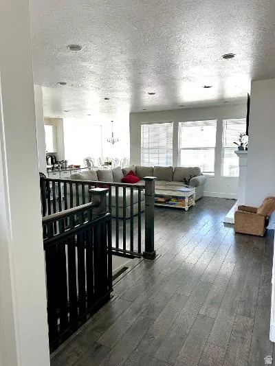 Wood-finish flooring throughout, multiple windows with blinds, recessed lighting, and a white fireplace