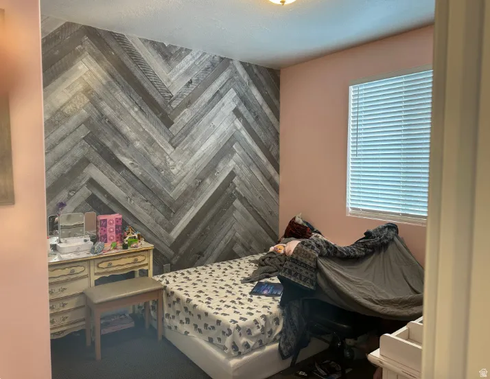 Accent wall with a herringbone wood-finish pattern, window with horizontal blinds, and a built-in ceiling light fixture