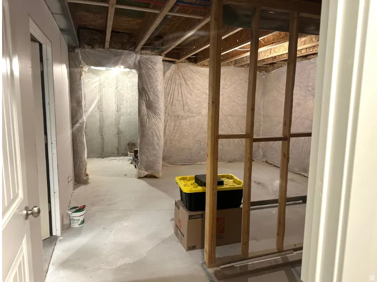 Unfinished basement space with wood framing, concrete floor, and exposed ceiling joists