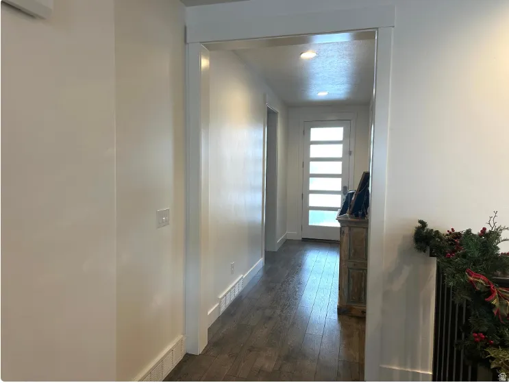Wood-finish flooring, recessed lighting, and a door with frosted glass panels