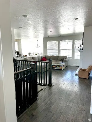 Wood-finish flooring throughout, multiple windows with blinds, recessed lighting, and a white fireplace