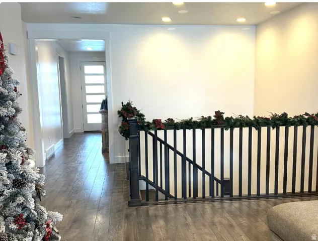 Christmas time. Wood-finish flooring, recessed ceiling lighting, and a dark-toned staircase railing with vertical balusters
