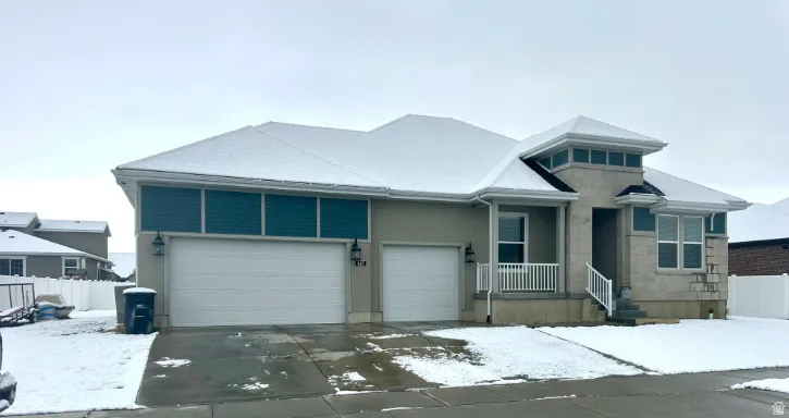 Contemporary stucco exterior with a stone accent facade, featuring a covered front entry and a multi-pane window design