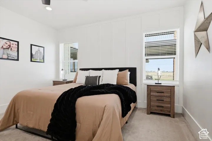 White shiplap accent wall, two windows with blinds, recessed lighting, and a ceiling fan
